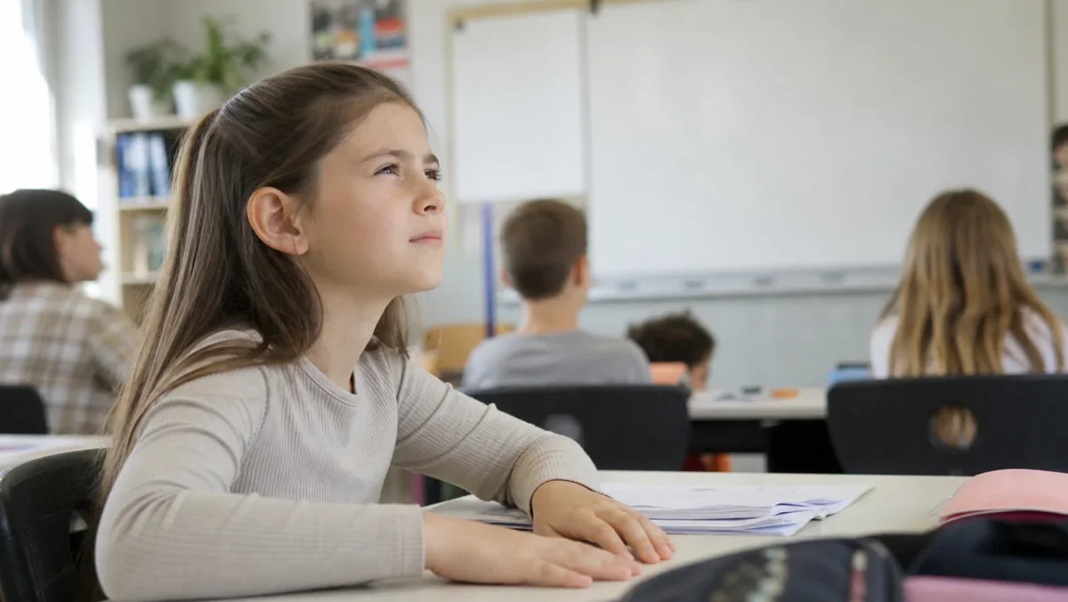 Školáčka žmúri pri pohľade na vzdialenú tabuľu v triede