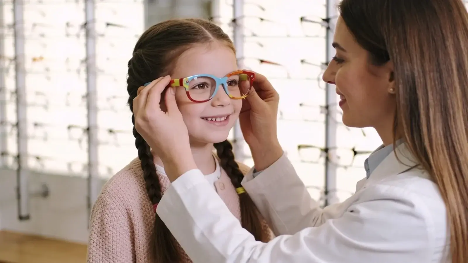 Predškolák skúša dioptrické okuliare u optika, optička mu upravuje sedenie rámu